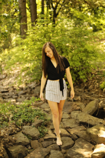 A girl wearing black walking on rocks
