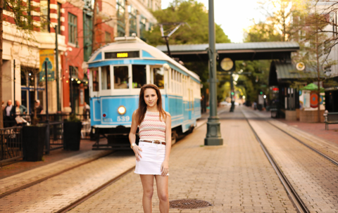 A girl standing with a train in the background