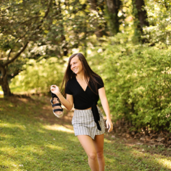 A girl in the woods walking barefoot and smiling