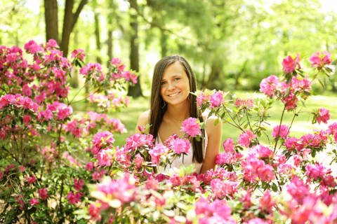 A girl in white dress with flower plants in front