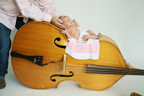A newborn baby on a big violin