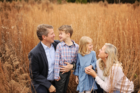 A family of four sitting with tall grasses