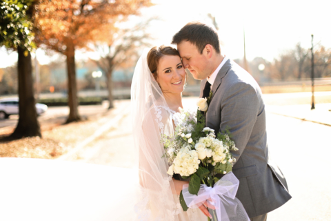 A bride and groom holding white flowers
