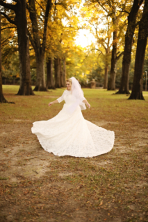 A bride posing with huge trees on both sides