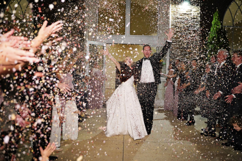 a man and a women walking with confetti being thrown at them