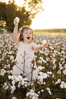 A small girl wearing white dress in the cotton fields