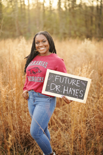 A woman holding a board written future Dr Hayes