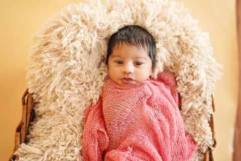 A newborn baby wrapped in red cloth