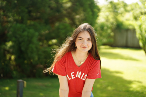 A girl in red tshirt with trees in the background