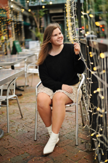 A lady sitting on a chair with lights all around her