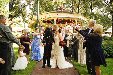 A bride and groom kissing with people around
