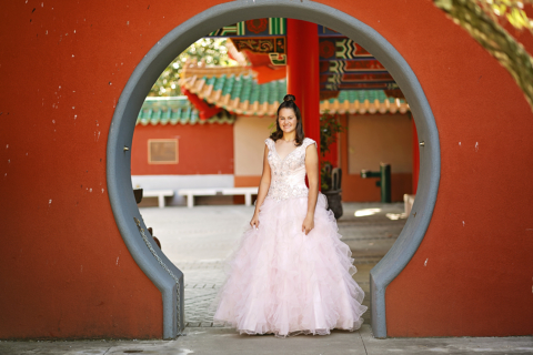 A girl standing in front of round shape gate