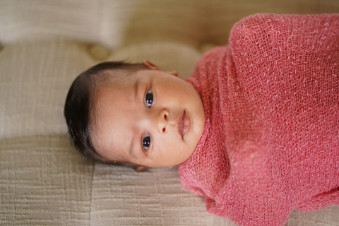 A newborn baby wrapped in red cloth