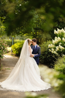A bride and groom standing on a road with trees all around