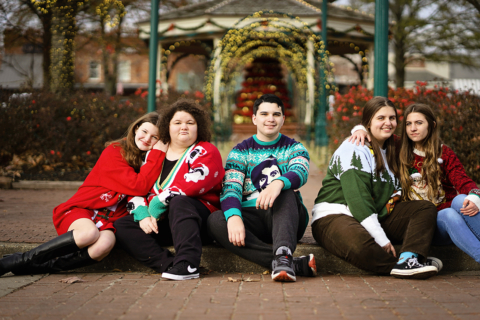 A family of five sitting on a pavement