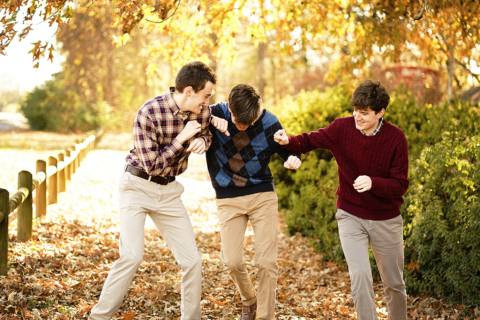 Three men having fun in front of trees