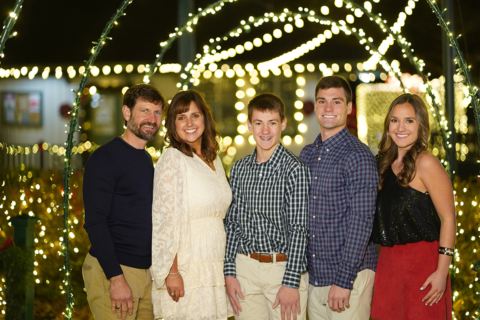 a group of people standing in front of light decorations