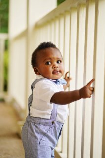 A small child standing beside the wooden fence