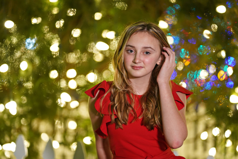 A girl wearing red dress with lights in background