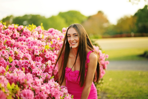 A girl in beautiful pink dress in front of pink flowers