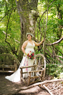 A bride beside wooden chairs in the forest