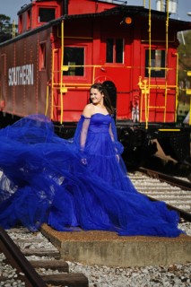 A woman wearing blue dress posing on railway line