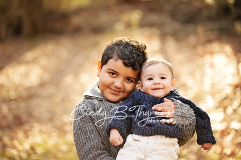 A small boy holding a newborn baby