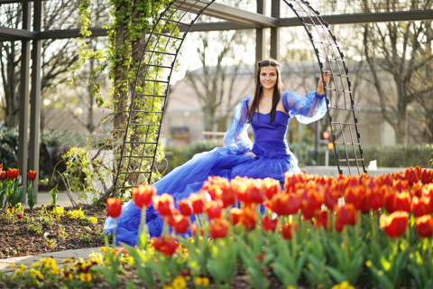 A girl wearing a long blue dress with flowers in front