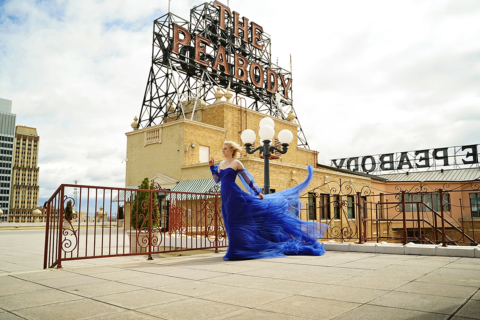 A woman in blue dress standing in front of the peabody