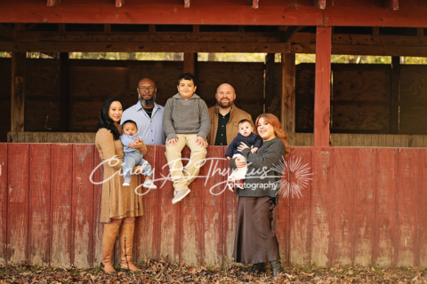 A family of seven posing in a wooden structure