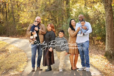 A family of seven walking on a road with trees all around