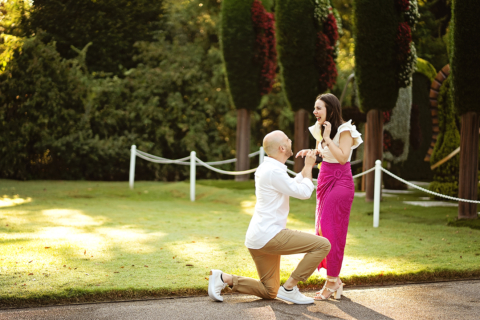 A man proposing a woman in front of a garden
