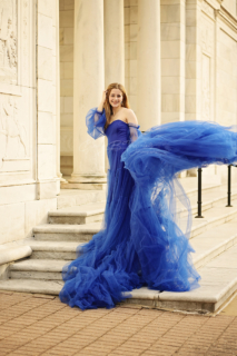 A girl wearing a long blue dress on the stairs