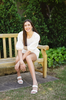 A girl sitting on a wooden bench