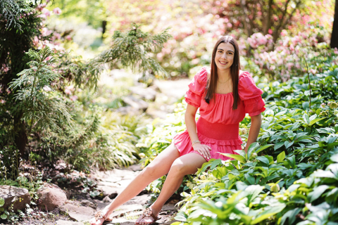 A women wearing pink dress and siting near plants