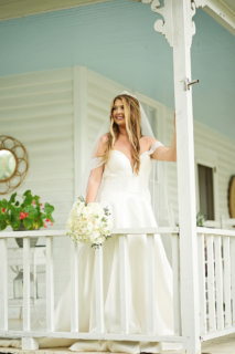 A bride standing on the white porch