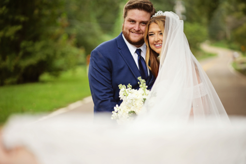 A bride and groom holding white flowers