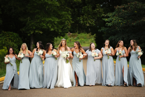 A bride with all her brides mate holding white flowers