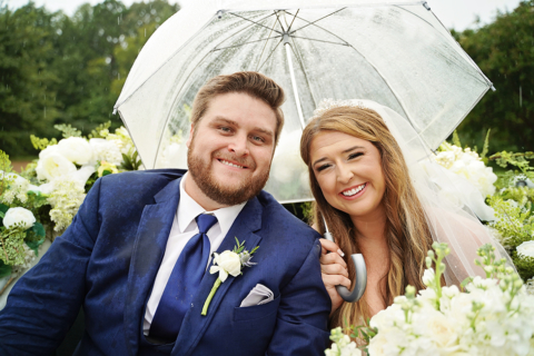 A bride and groom with a white umbrella