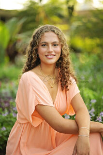 A woman siting with green background